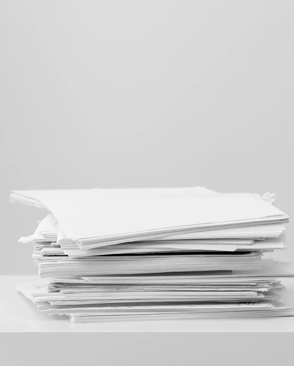 Pilha de documentos sobre uma mesa branca
